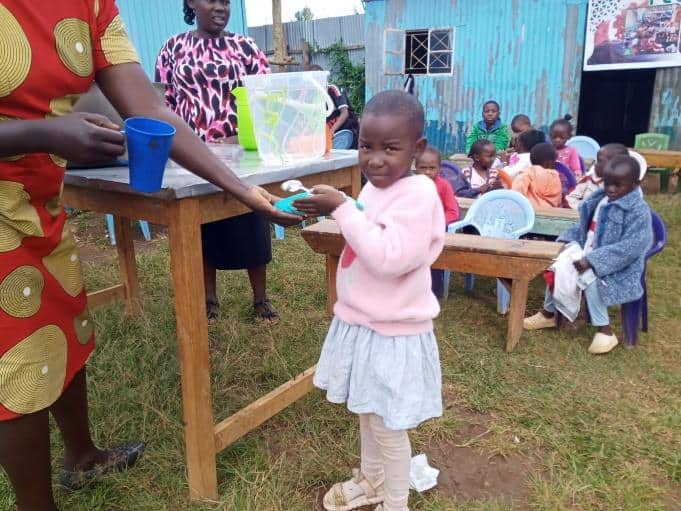 Shekina at the feeding center, grabbing a plate of food