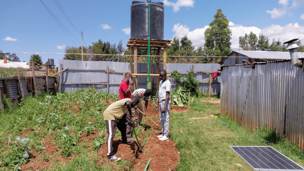 Community members working together to install a water storage system with a solar panel in a rural setting, indicative of sustainable development efforts.