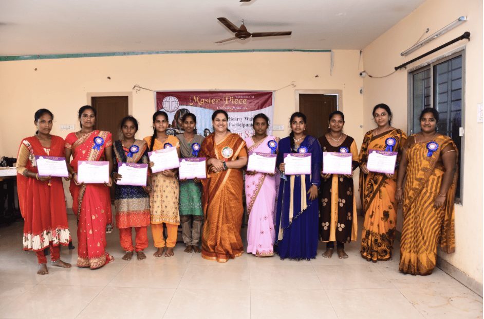 New graduates from the sewing school holding their certificates for completing and passing the course.