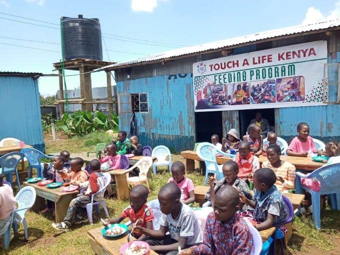 Children eating outside of Agape Baptist Church at the feeding center located there.