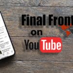 A smartphone displaying the 'Final Frontiers' YouTube channel rests on a wooden surface. Beside it are bold texts that read 'Final Frontiers on YouTube' with a stylized map of the world in the background, highlighting various regions in red, and the YouTube logo at the bottom.