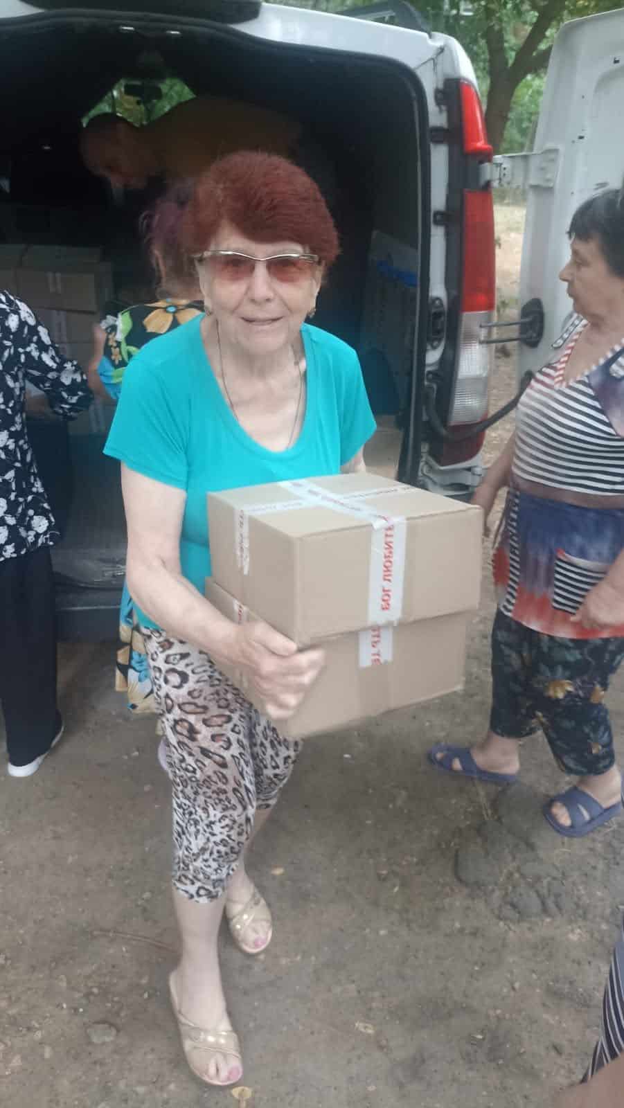 A widow receives a food package through the feeding ministry.