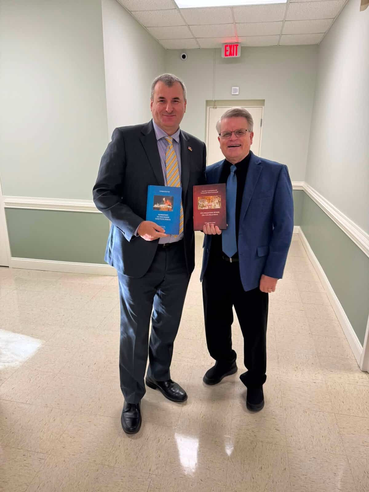 Oleh, with a fellow pastor, holding recently published Ukrainian theological translations.