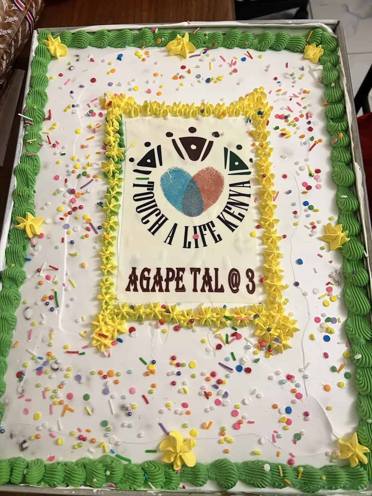 Anniversary sheet cake decorated with the Touch A Life Kenya logo and the words “Agape TAL @ 3”