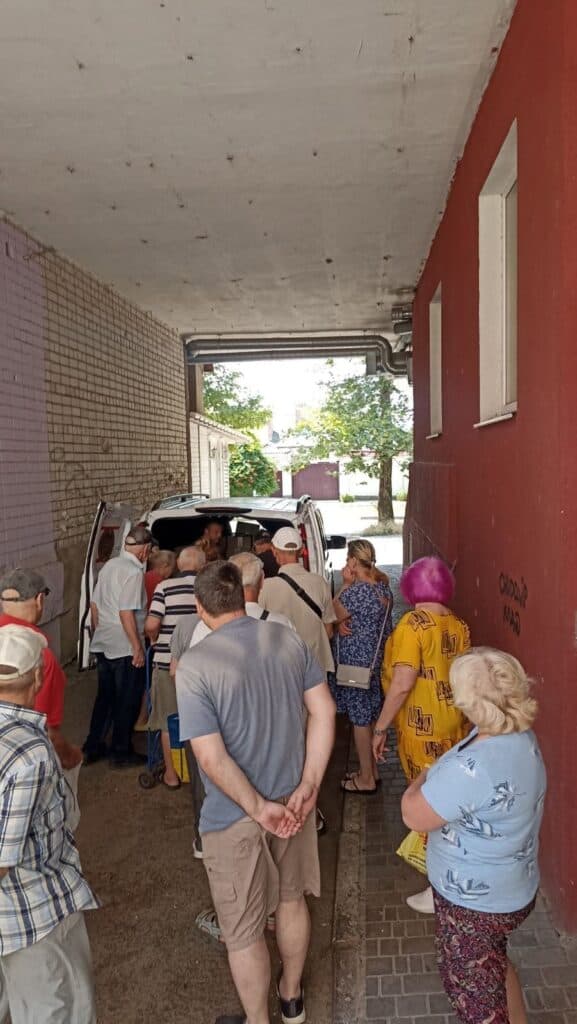 People line up at a van to receive humanitarian aid boxes in Ukraine