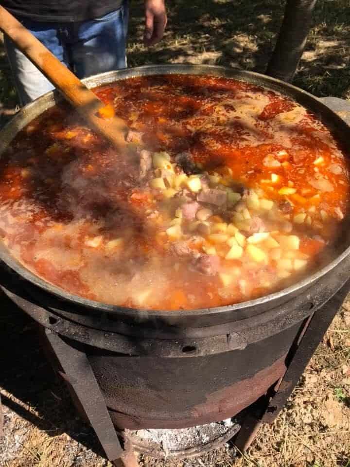 A large pot of stew cooking over a fire for the refugee feeding ministry